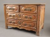 une vieille commode en bois ornée de sculptures et de poignées décoratives