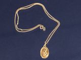 un collier plaqué or avec une pièce suspendue à une chaîne
