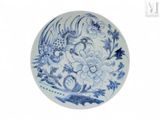 une assiette bleue et blanche ornée d'un oiseau et de fleurs
