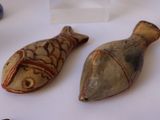 two pieces of pottery sitting on a table next to each other