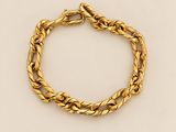 un bracelet en or orné d'une corde torsadée sur fond beige