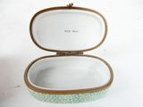 a white and green box with a gold trim on it