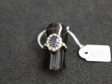 a close up of a ring on a black surface with a price tag