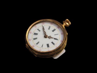 une petite montre de poche en or dont le cadran est orné de chiffres romains