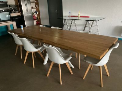 a wooden table with white chairs around it in a room