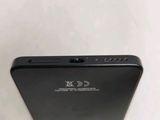 the back of a black cell phone sitting on top of a white table