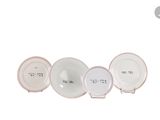 three white and pink plates with numbers on them sitting next to each other