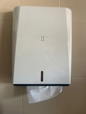 a paper towel dispenser on the wall in the bathroom