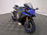 une photo d'une moto bleue garée sur un sol à damier