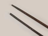 two wooden chopsticks sitting next to each other on a white surface