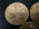 three gold coins sitting on top of each other on a black surface