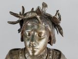 silver statue of a woman with a bird on her head