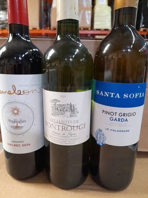 trois bouteilles de vin sont alignées sur une table