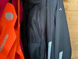 two jackets hanging up on a rack in a store