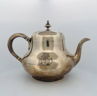 an antique silver teapot with a monogram on the lid
