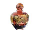 a glass vase with a red and gold design on it