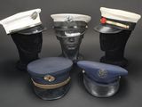 three hats and a hat cap sitting on top of a black table