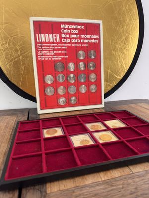a close up of a box of coins on a table near a mirror