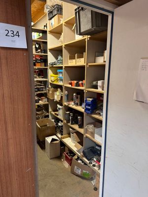 une pièce avec de nombreuses étagères et une pancarte sur la porte