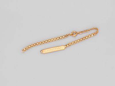 un bracelet plaqué or composé d'une barre suspendue à une chaîne