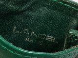 someone is holding a green purse that has a tag on it