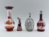 four different colored glass vases sitting next to each other on a white surface