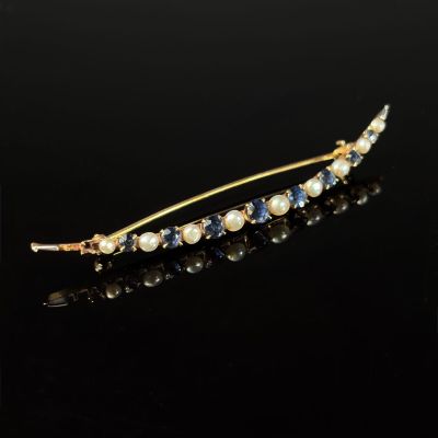 a close up of a gold hair pin with pearls and sapphires