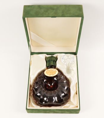 une image représentant une bouteille d'alcool dans un coffret, posée sur une surface blanche