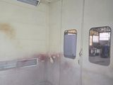 a dirty room with two windows and a grate on the floor