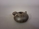 a small metal object on a table with a white background