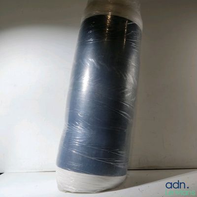 un objet bleu et blanc emballé dans du plastique, posé sur une étagère