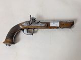 un gros plan d'un pistolet posé sur une surface blanche, avec une étiquette dessus