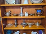 a wooden bookcase with a lot of silver items on top of it