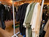 a rack of clothes in a clothing store with clothes hanging on it