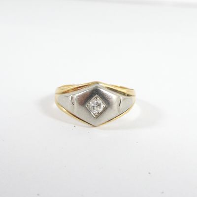 une bague en or et en argent, ornée d'un diamant serti au centre