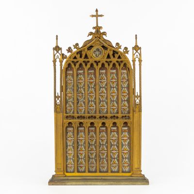 a gold and blue stained glass window with a cross on top