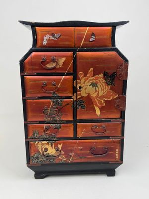 une image représentant une commode en bois décorée de fleurs et de papillons peints
