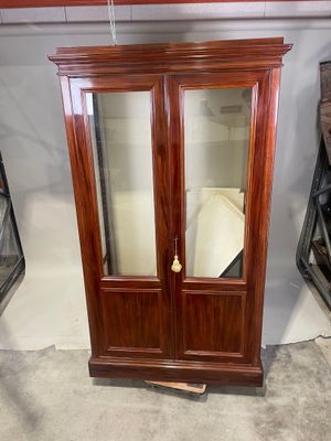 un meuble en bois avec une porte en verre dans une pièce