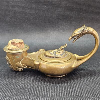 une image représentant une théière en laiton ornée d'une tête de dragon