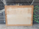 an old picture frame sitting on the ground in front of a graffiti covered wall