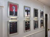 de nombreux tableaux encadrés accrochés au mur d'un couloir