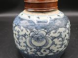 a close up of a blue and white jar with a wooden lid