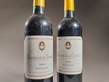 two bottles of wine sitting on top of a table next to each other