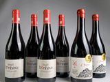 six bouteilles de vin rouge sont alignées