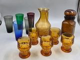 des bouteilles et des verres sont alignés sur une table à fond blanc
