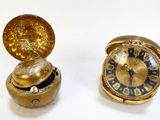 deux horloges placées l'une à côté de l'autre sur une surface blanche