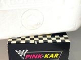 a box of pink kar sitting on top of a toilet