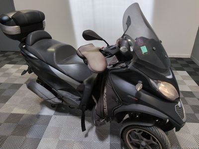 un scooter garé sur un sol à damier