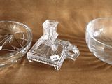 a glass bowl and a glass candle holder on a brown cloth