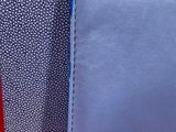 the back of a blue and white purse with a red handle